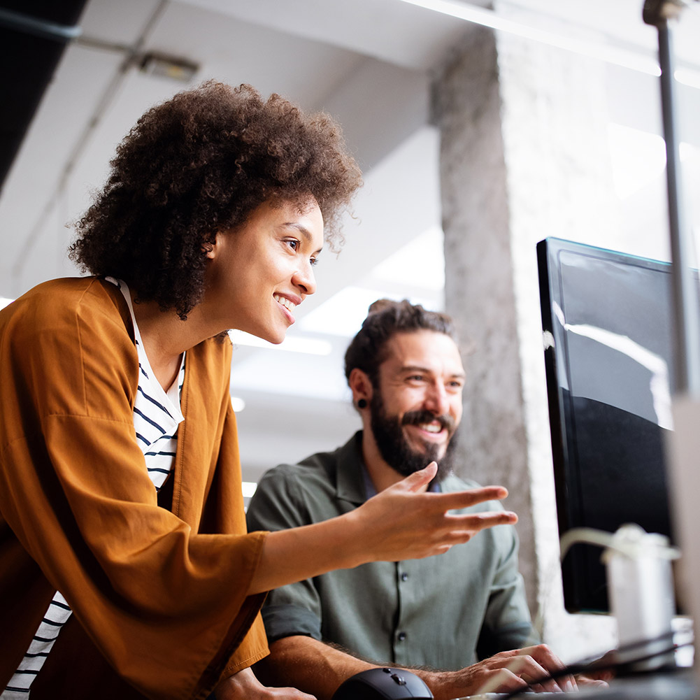 smiling woman showing man computer screen